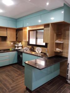 a kitchen with blue cabinets and a black counter top at Villa Dar Nejib - Duplex de luxe 2S+4 à cité El Wafa in Nabeul
