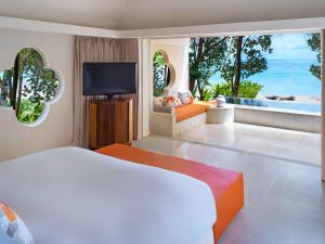 ベル・オンブルにあるSO/ Sofitel Mauritiusのベッドとテレビが備わるホテルルームです。
