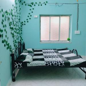 a bed in a blue room with a window at Maya home stay in Kolkata
