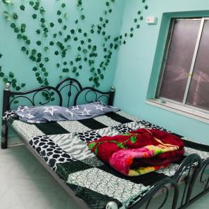 Maya home stay في كولْكاتا: غرفة نوم بسريرين ونافذة