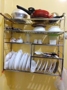 a rack of dishes and utensils in a kitchen at Maya home stay in Kolkata