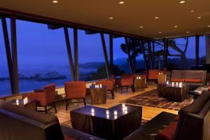 restauracja ze stołami i krzesłami oraz widokiem na ocean w obiekcie Hyatt Carmel Highlands w mieście Carmel