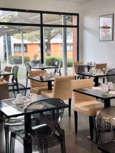 un restaurante con mesas y sillas y una gran ventana en Best Western Hôtel De La Cité & Spa, en Guérande