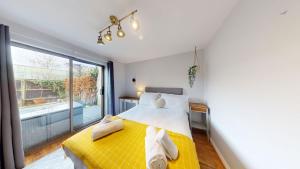 1 dormitorio con cama amarilla y ventana grande en Bannister House, en Oxford