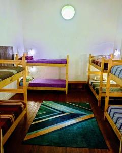 Cette chambre comprend 3 lits superposés et un tapis. dans l'établissement Origenes, à Santiago