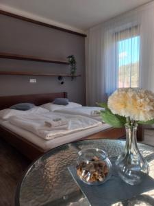 een slaapkamer met een bed en een tafel met een vaas met bloemen bij Penzion Ve Vinohradě in Němčičky