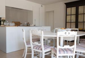 cocina con mesa blanca y sillas blancas en Villa Beaumont 84MONT, en Malaucène