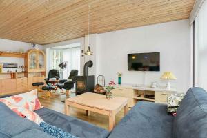 sala de estar con sofá y mesa en Nice Summer House , Spa, Sauna, Wood Stove, Tv, en Sønderby