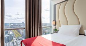 een hotelkamer met een bed en een groot raam bij Best Western Plus Plaza Almere in Almere