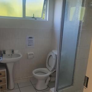 a bathroom with a toilet and a sink at Laguna La Crete Beach Apartment 206 in Margate