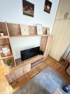 una sala de estar con un centro de entretenimiento de madera con TV en Apartment Boulevard, en Belgrado