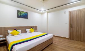 a bedroom with a large bed with a colorful blanket at Itsy By Treebo - Krishna Residency, Govardhan Chauraha in Mathura