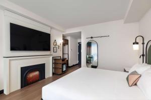 a white bedroom with a large bed and a fireplace at Onyx Boston Downtown in Boston