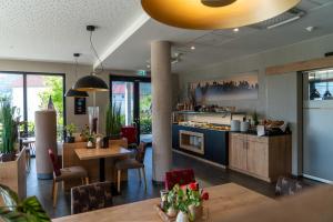 um restaurante com mesas e cadeiras e uma cozinha em Hotel Schlossberg Wehingen em Wehingen