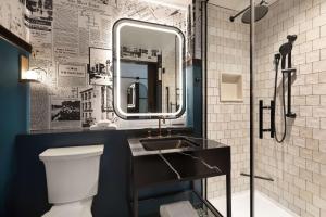 a bathroom with a sink and a mirror at Pennyweight Hotel Boston, Curio Collection by Hilton in Boston +25 photos
