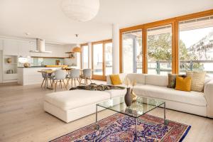 オーバータウエルンにあるHotel Manggei Designhotel Obertauernのリビングルーム(白いソファ、ガラスのテーブル付)