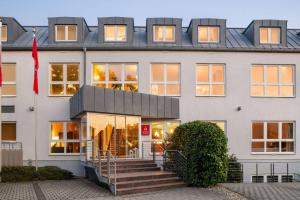 a large white building with a staircase in front of it at Amedia Frankfurt Russelsheim Trademark Collection by Wyndham in Rüsselsheim