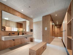 bagno con pareti in legno, lavandino e panca di Loxone Campus a Kollerschlag