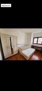 1 dormitorio grande con 2 camas y ventana en V.V. familiar en Arinaga