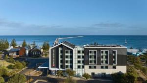 an aerial view of a building with the ocean in the background at Hilton Garden Inn Busselton in Busselton