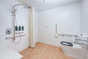 a white bathroom with a toilet and a shower at Hilton Garden Inn Busselton in Busselton