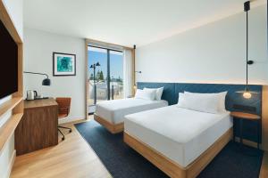 a hotel room with two beds and a tv at Hilton Garden Inn Busselton in Busselton