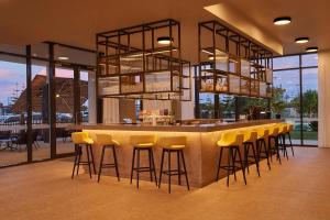 a bar with yellow bar stools in a restaurant at Hilton Garden Inn Busselton in Busselton