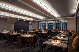 a restaurant with tables and chairs and a large window at Mystic Marriott Hotel and Spa in Groton