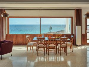 une salle à manger avec une table et des chaises et l'océan dans l'établissement Playa Marina Eco Beach Villa, à Arrieta
