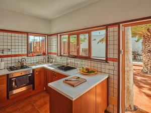 a kitchen with a sink and a counter with windows at Playa Marina Eco Beach Villa in Arrieta