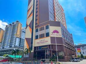 Un edificio alto con una palmera. en Hotel Tanjong Vista, en Kuala Terengganu
