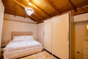 a bedroom with a bed and a closet at House La Frateli in Korçë