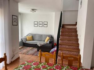 uma sala de estar com um sofá e uma escada em Lovely family house by the golf course em Huelva