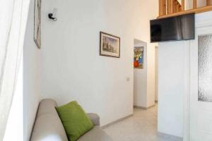 een woonkamer met een bank met een groen kussen bij Donna Sara Appartamento in corte Amalfitana in Amalfi