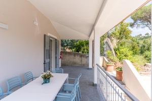 a patio with a white table and blue chairs at Elbitat Homes in Bagnaia