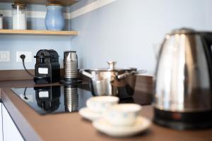 un bancone della cucina con tazze e una macchinetta del caffè di Elbitat Homes a Bagnaia