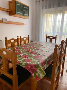 una mesa de comedor con un mantel de flores. en Lovely family house by the golf course, en Huelva