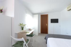 a white room with a desk and a bed and a table at Ático, Studio 300 meters from Cathedral and Giralda in Seville