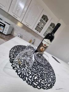 - une bouteille de vin et un verre de vin sur un comptoir dans l'établissement Apartman Sparta, à Sombor