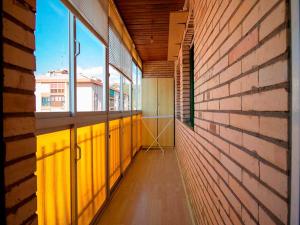 an empty hallway with windows and a brick wall at Apartamentos Jaca Ciudadela 3000 in Jaca