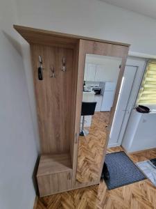a large wooden cabinet in a room with a kitchen at Apartman Sparta in Sombor