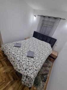a bedroom with a bed with two pillows on it at Apartman Sparta in Sombor