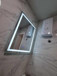 a bathroom with a mirror and a sink at Apartman Sparta in Sombor