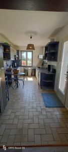 a kitchen with a table and a sink in a room at La longère en campagne in Louans