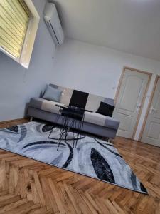 a living room with a couch and a rug at Apartman Sparta in Sombor