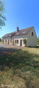 a large white house with a large yard at La longère en campagne in Louans