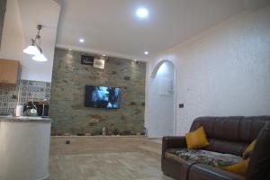 een woonkamer met een bank en een tv aan een stenen muur bij Spacious Appartement in Agadir only for families in Agadir