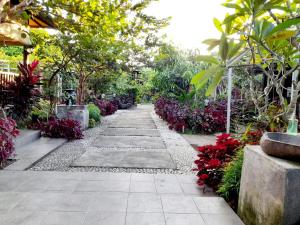 a walkway in a garden with flowers and plants at PURI LESTARI in Sorongjukung