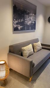 a couch in a living room with a picture on the wall at Pequeño loft para dos in Sant Feliu de Guixols