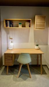 un bureau en bois avec une chaise verte et une lampe dans l'établissement Pequeño loft para dos, à Sant Feliu de Guíxols